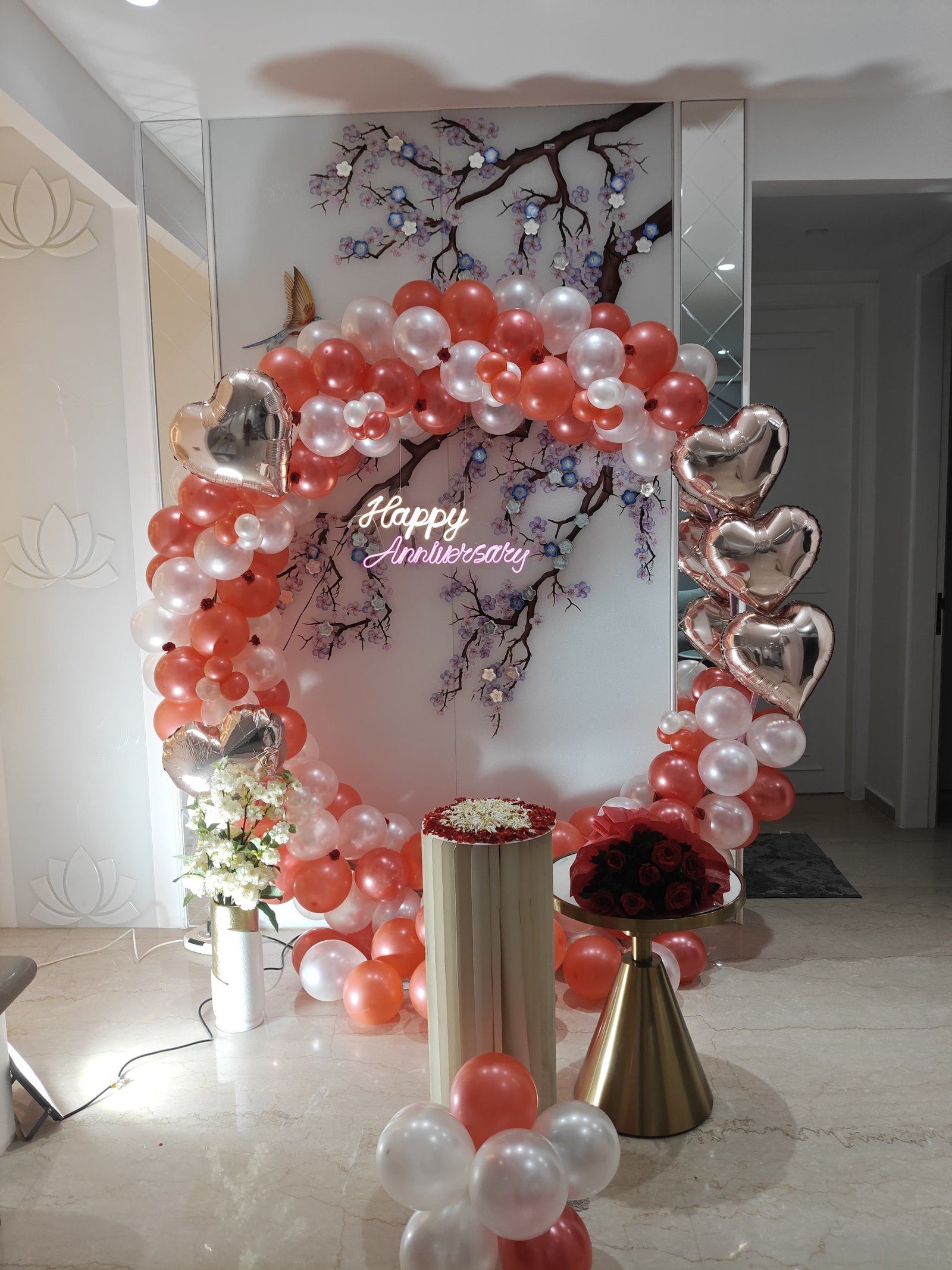 Red and white anniversary balloon arch with silver heart balloons